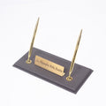 Gray desk nameplate base with two gold-tone pens and a personalized gold-tone plate