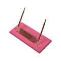 Pink desk nameplate base with two gold-tone pens and a personalized gold-tone plate