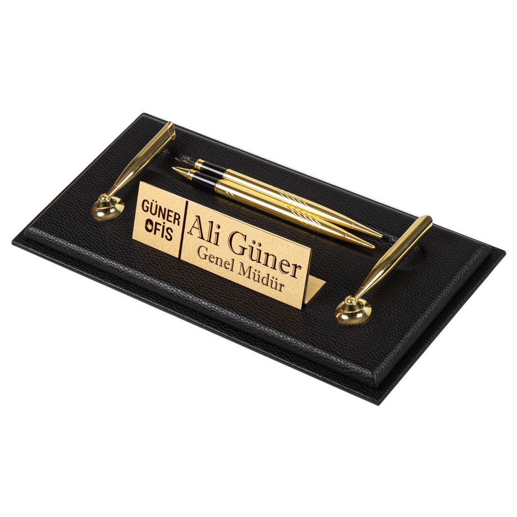Black textured desk nameplate base with a personalized gold-tone plate, two gold-tone pens laid flat and two pen holders
