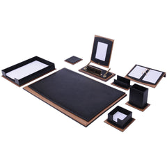A matching desk organizer set featuring a large black desk mat with a brown leather-look border, a black tray, a black stand with a white insert, a black notebook, a black folder, and small black boxes, all arranged on a plain white background.