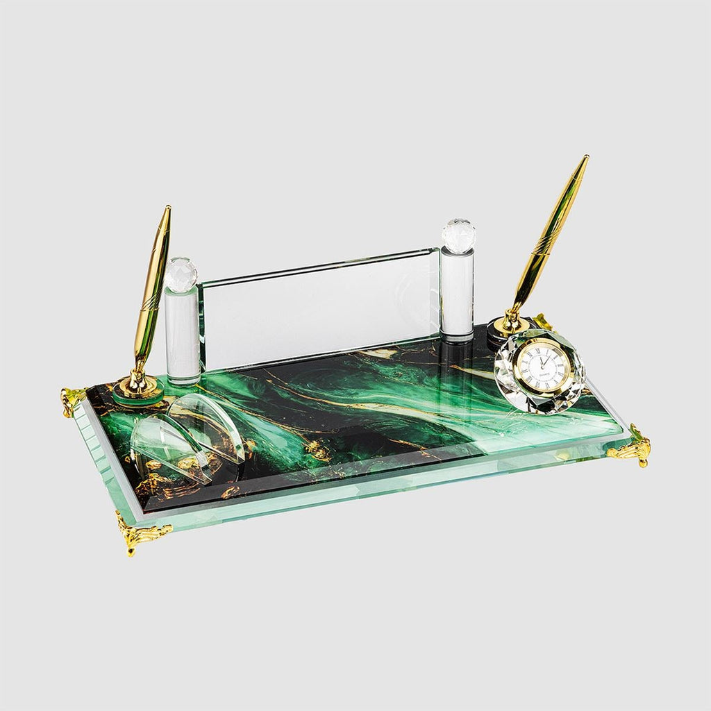 Clear glass desk nameplate set with two gold-tone pens, a clock and a card holder on a green marble-patterned rectangular base