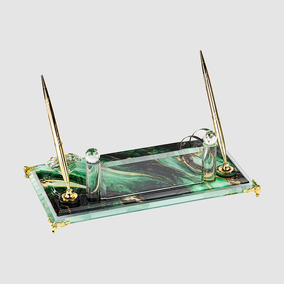 Clear glass desk nameplate set viewed from behind, with two gold-tone pens and a curved card holder on a green marble-patterned base