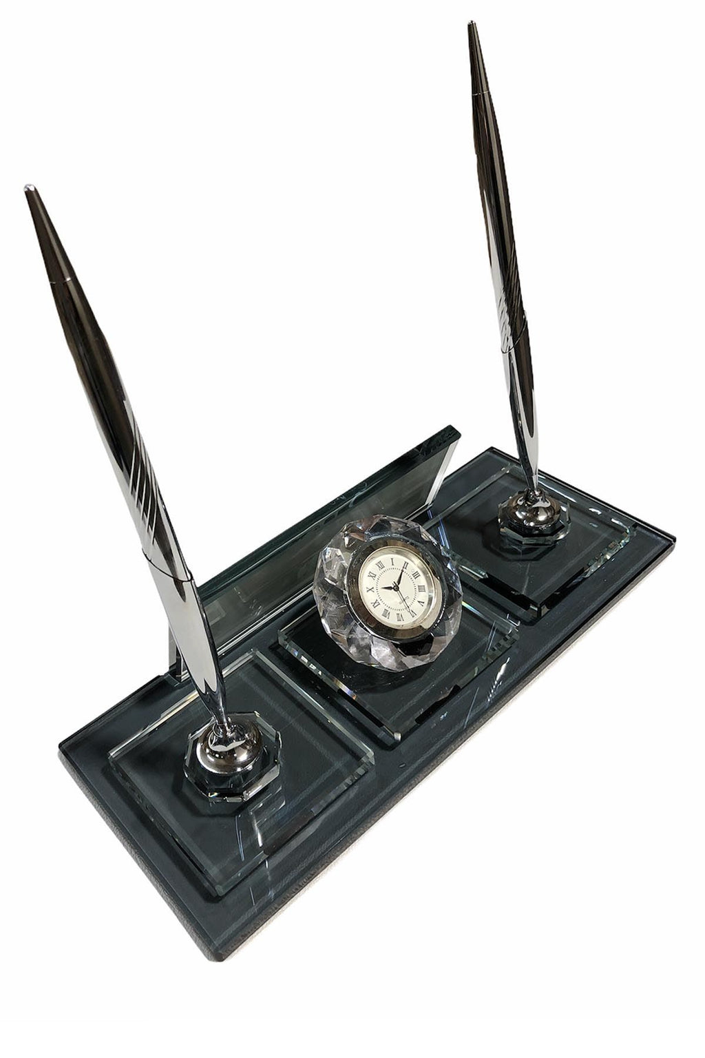 Dark glass desk nameplate with two silver-colored pens and a central round clock, viewed from the reverse side.